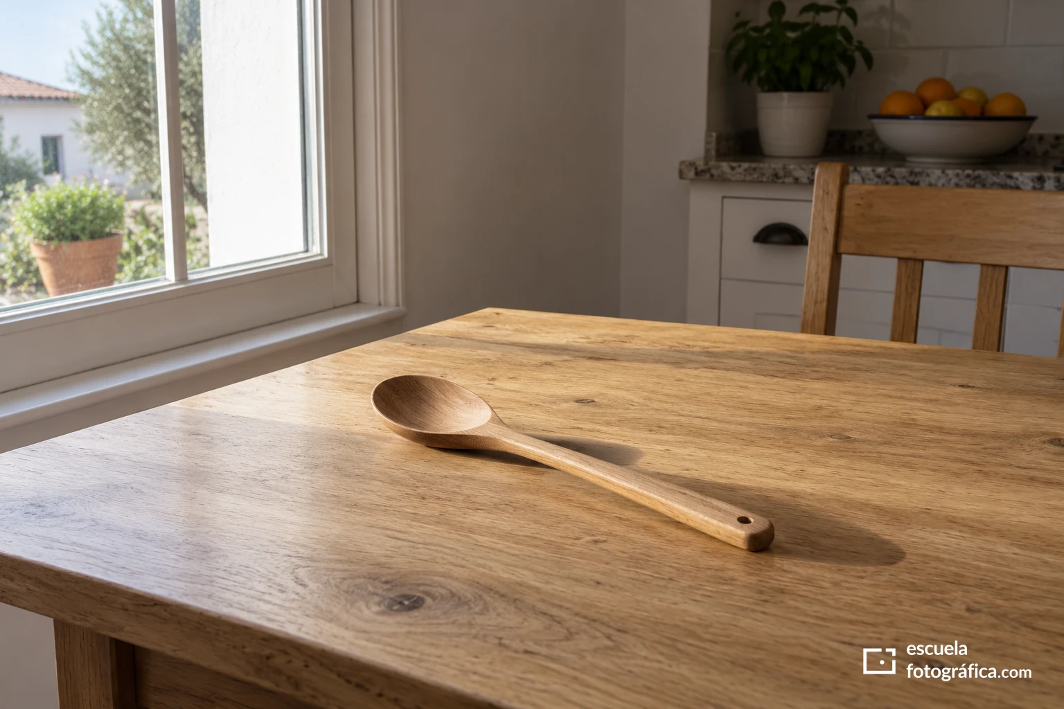 Cuchara de madera y su sombra sobre una mesa próxima a una ventana lateral