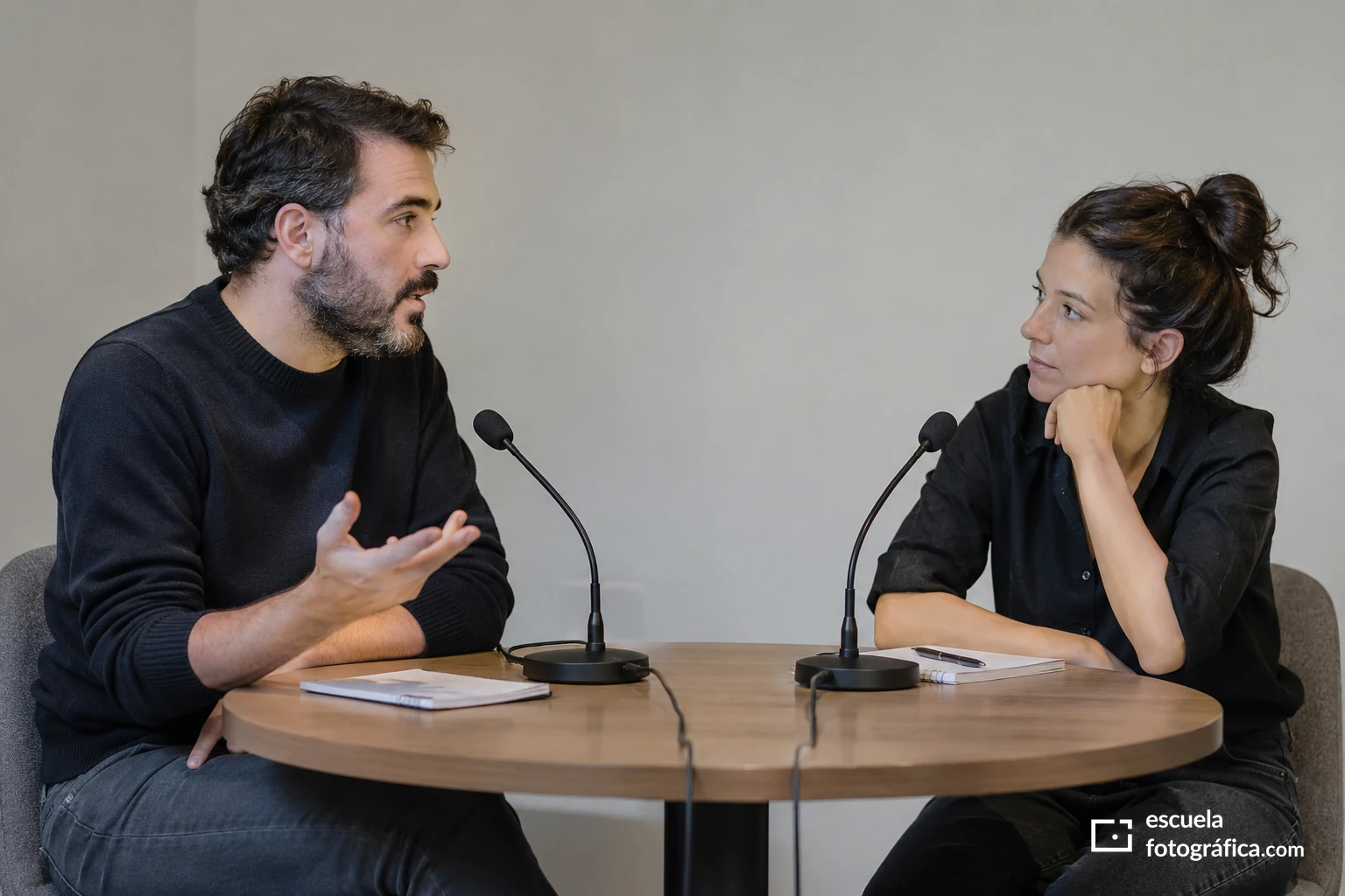 Dos participantes de una mesa redonda, uno hablando y otro escuchando